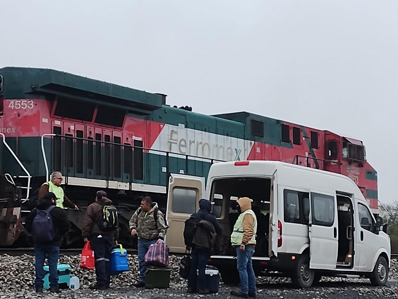 Tripulación ferroviaria abordando una unidad de Alcovar junto a una locomotora
